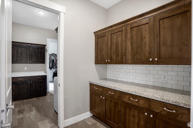 3691 W 2800 S, Hurricane, UT 84737 - kitchen with decorative backsplash, dark wood-style flooring, dark brown cabinets, light stone countertops, and baseboards
