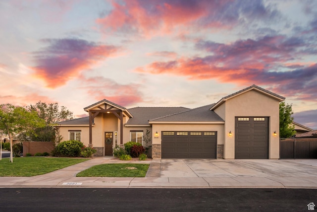 3691 W 2800 S, Hurricane, UT 84737 - view of front of home featuring a garage, concrete driveway, stucco siding, a tile roof, and stone siding