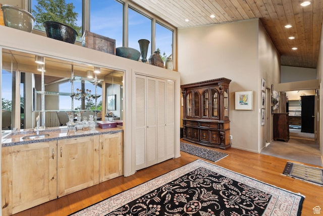 4517 S Abinadi Rd, Millcreek, UT 84124 - interior space featuring wooden ceiling, a towering ceiling, light brown cabinetry, healthy amount of natural light, and hardwood / wood-style flooring