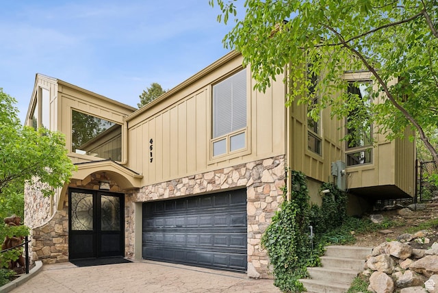 4517 S Abinadi Rd, Millcreek, UT 84124 - view of front of home with stone siding, an attached garage, french doors, and board and batten siding