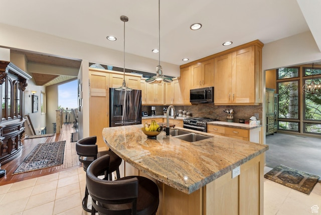 4517 S Abinadi Rd, Millcreek, UT 84124 - kitchen with appliances with stainless steel finishes, backsplash, light brown cabinetry, light stone countertops, and a center island with sink