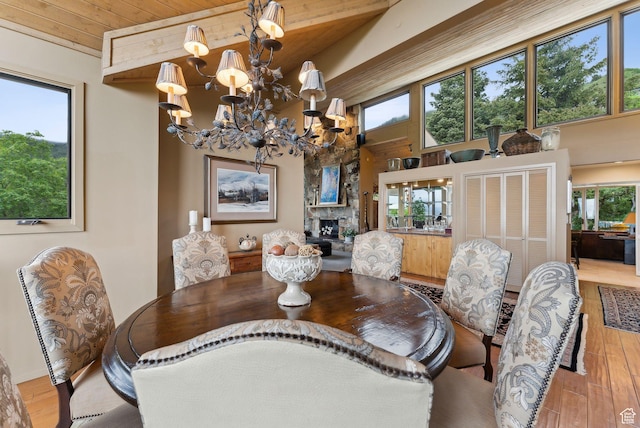 4517 S Abinadi Rd, Millcreek, UT 84124 - dining area with wood finished floors, a chandelier, a fireplace, and wooden ceiling