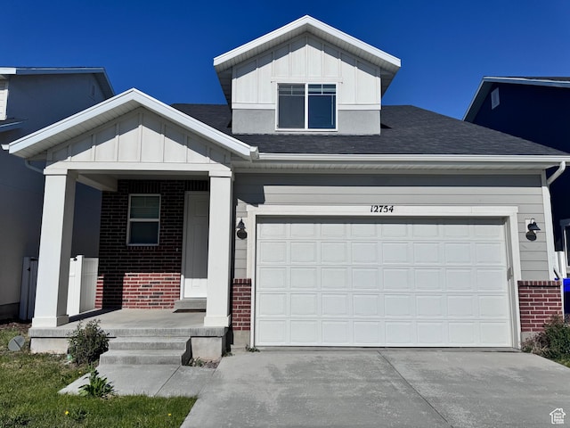 12754 S Quail Lake Dr Unit 126, Riverton, UT 84096 - view of front of home featuring brick siding, board and batten siding, driveway, and roof with shingles