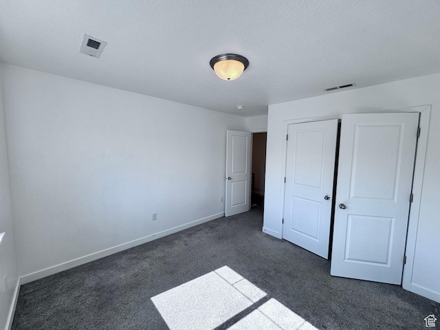 12754 S Quail Lake Dr Unit 126, Riverton, UT 84096 - unfurnished bedroom featuring dark colored carpet, baseboards, and a closet