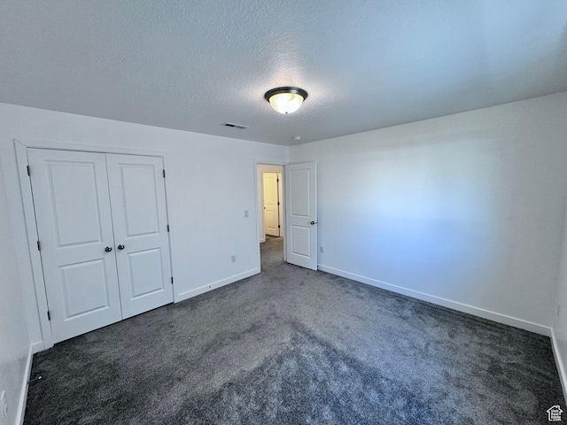 12754 S Quail Lake Dr Unit 126, Riverton, UT 84096 - unfurnished bedroom with dark colored carpet, baseboards, a textured ceiling, and a closet