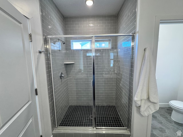 12754 S Quail Lake Dr Unit 126, Riverton, UT 84096 - full bathroom featuring a stall shower, toilet, a textured ceiling, and baseboards