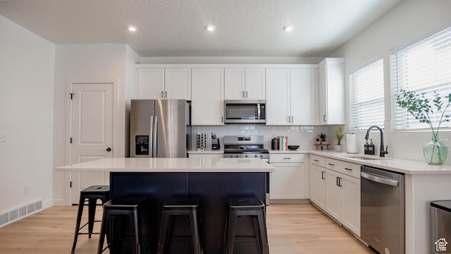 4357 E Longleaf Ln, Eagle Mountain, UT 84005 - kitchen featuring stainless steel appliances, a sink, a kitchen bar, a center island, and decorative backsplash