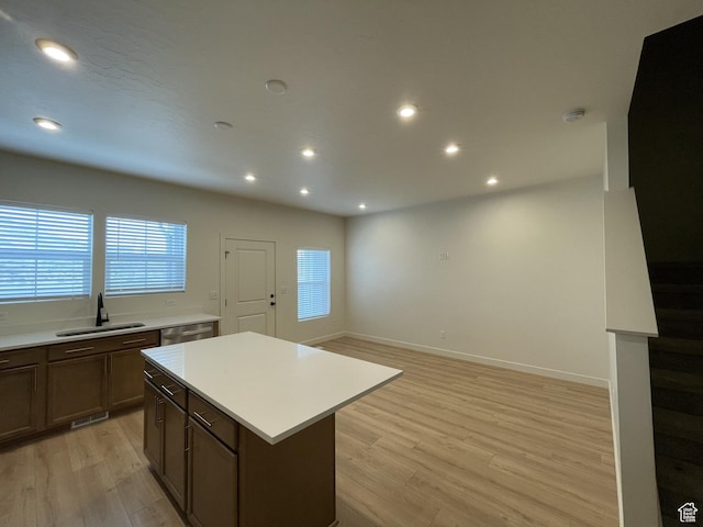 4357 E Longleaf Ln, Eagle Mountain, UT 84005 - kitchen with a sink, light wood-style flooring, light countertops, a kitchen island, and plenty of natural light
