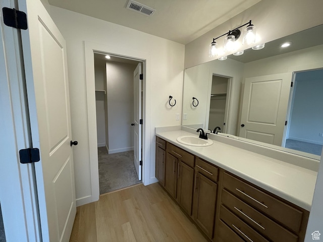 4357 E Longleaf Ln, Eagle Mountain, UT 84005 - bathroom featuring wood finished floors, vanity, baseboards, recessed lighting, and a walk in closet