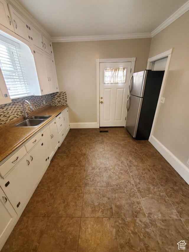 827 E Third Ave N, Salt Lake City, UT 84103 - kitchen with a sink, freestanding refrigerator, ornamental molding, white cabinetry, and tasteful backsplash
