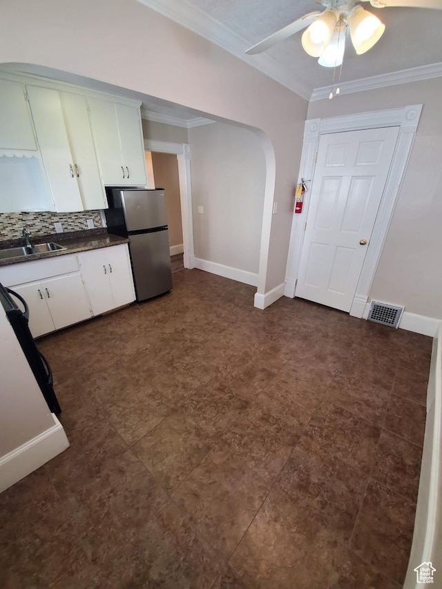 827 E Third Ave N, Salt Lake City, UT 84103 - kitchen with a sink, freestanding refrigerator, dark countertops, ornamental molding, and arched walkways
