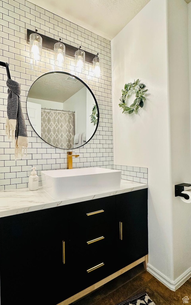 146 S 1125 W, Layton, UT 84041 - bathroom featuring vanity, decorative backsplash, a textured ceiling, and baseboards