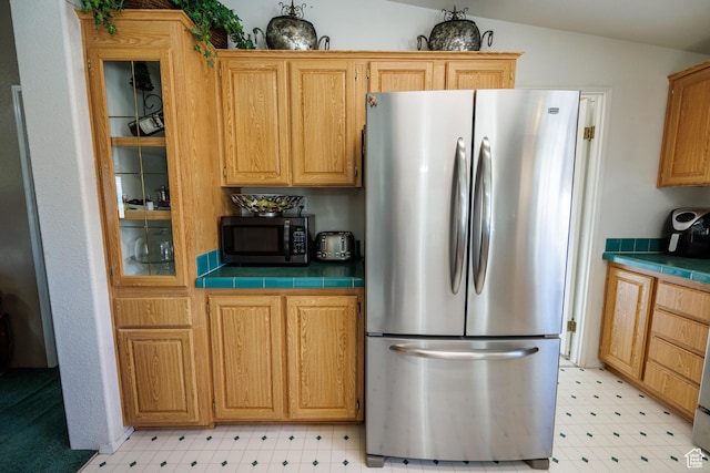 1085 S S River Ridge Ln, Joseph, UT 84739 - kitchen featuring appliances with stainless steel finishes, light floors, tile countertops, glass insert cabinets, and vaulted ceiling