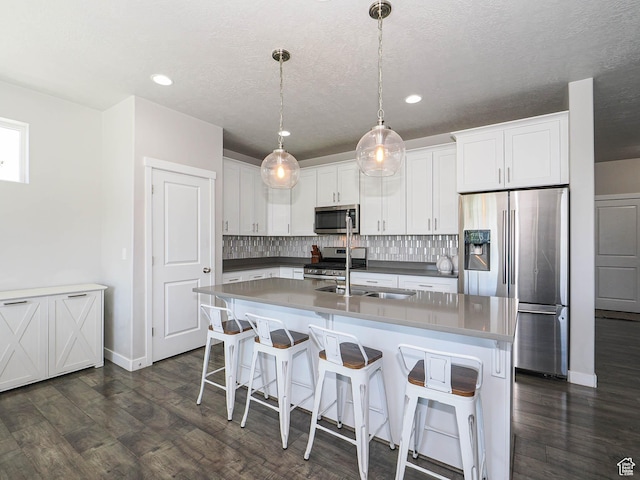 957 W Mckenna Rd, Bluffdale, UT 84065 - kitchen with appliances with stainless steel finishes, tasteful backsplash, white cabinetry, baseboards, and dark wood-style flooring