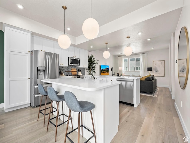 1031 W 360 S, American Fork, UT 84003 - kitchen with stainless steel appliances, a center island, light wood-style flooring, a peninsula, and white cabinetry