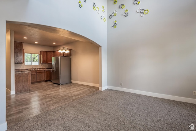 5242 W Cool Water Way S, West Jordan, UT 84081 - kitchen with stainless steel refrigerator with ice dispenser, arched walkways, baseboards, a chandelier, and open floor plan