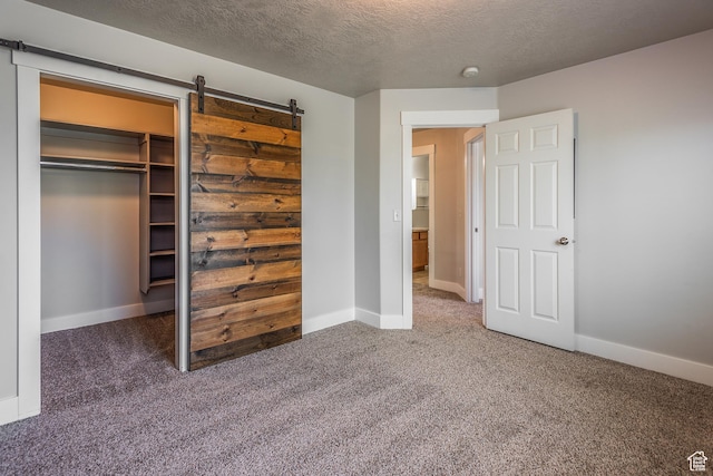 5242 W Cool Water Way S, West Jordan, UT 84081 - unfurnished bedroom featuring carpet floors, a textured ceiling, baseboards, a closet, and a barn door