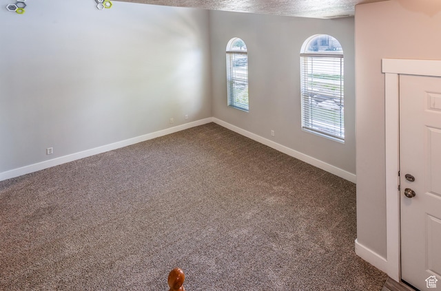 5242 W Cool Water Way S, West Jordan, UT 84081 - unfurnished room featuring dark colored carpet, baseboards, and a textured ceiling