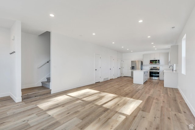 515 N 600 E, Spanish Fork, UT 84660 - unfurnished living room featuring recessed lighting, stairway, baseboards, light wood-type flooring, and a sink