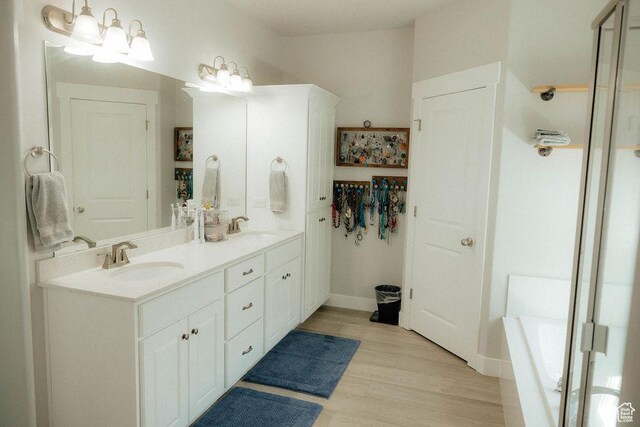 217 S 1230 W Unit 15, Spanish Fork, UT 84660 - bathroom with double vanity, a garden tub, wood finished floors, and baseboards