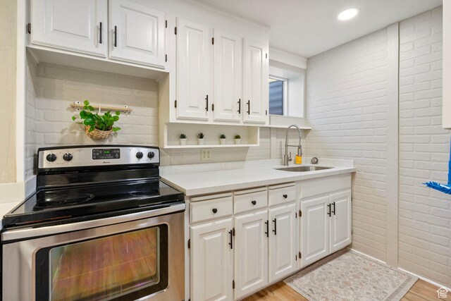 177 S Canyon Ave, Springville, UT 84663 - kitchen with stainless steel electric range, a sink, light countertops, white cabinets, and brick wall