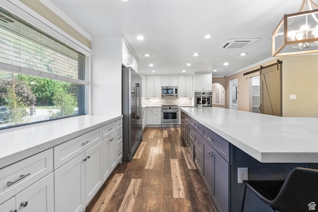 177 S Canyon Ave, Springville, UT 84663 - kitchen with high end appliances, a barn door, white cabinets, crown molding, and tasteful backsplash