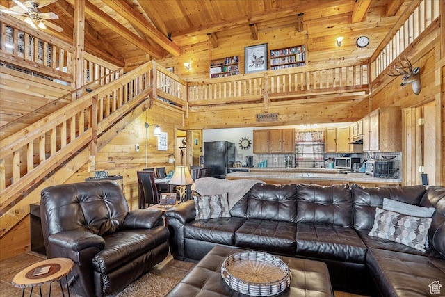 9911 S Antelope Xing, Duchesne, UT 84021 - living area featuring wooden walls, wooden ceiling with exposed beams, a high ceiling, a ceiling fan, and stairs