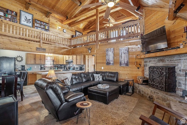 9911 S Antelope Xing, Duchesne, UT 84021 - living room featuring a ceiling fan, wooden walls, wooden ceiling with exposed beams, high vaulted ceiling, and a fireplace