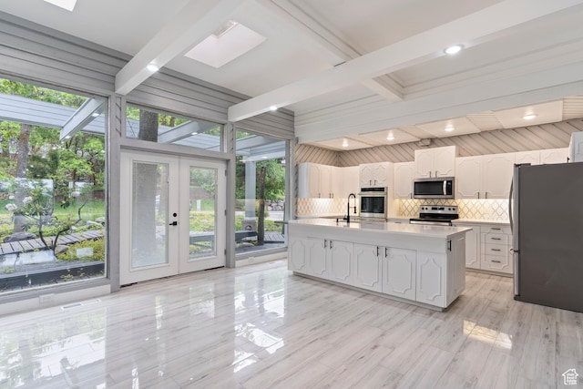 4203 S College Dr E, Ogden, UT 84403 - kitchen featuring appliances with stainless steel finishes, white cabinetry, beamed ceiling, tasteful backsplash, and a skylight