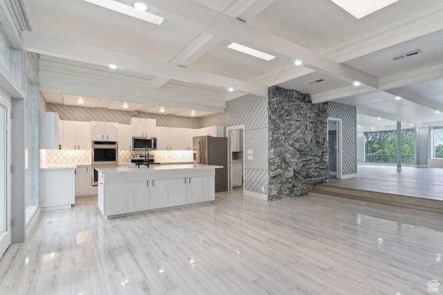 4203 S College Dr E, Ogden, UT 84403 - kitchen with stainless steel appliances, light countertops, beam ceiling, decorative backsplash, and an island with sink