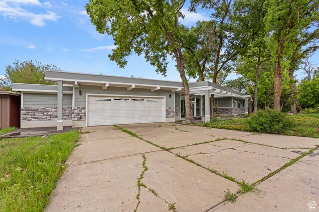 4203 S College Dr E, Ogden, UT 84403 - mid-century home featuring a garage, driveway, and stone siding