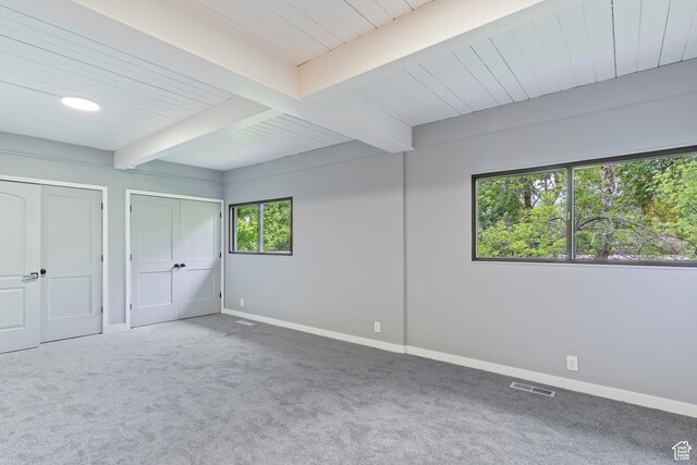 4203 S College Dr E, Ogden, UT 84403 - unfurnished bedroom featuring baseboards, beamed ceiling, carpet flooring, and two closets