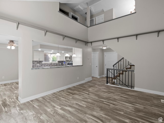 3095 W 8525 S, West Jordan, UT 84088 - spare room with wood finished floors, stairs, baseboards, and a high ceiling