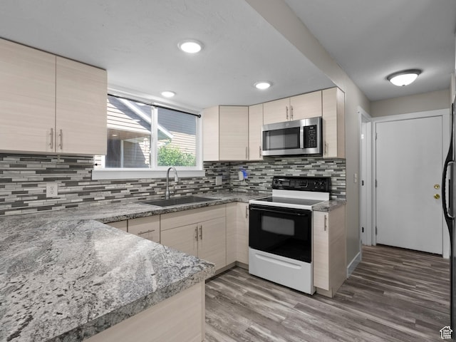 3095 W 8525 S, West Jordan, UT 84088 - kitchen featuring stainless steel microwave, a sink, electric range oven, decorative backsplash, and light wood-type flooring
