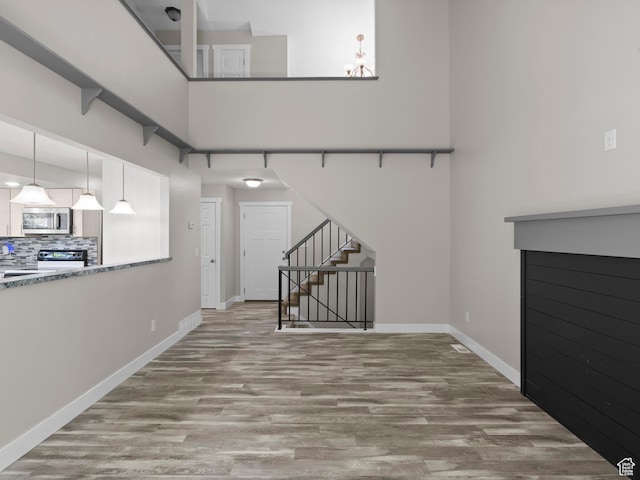 3095 W 8525 S, West Jordan, UT 84088 - unfurnished living room with wood finished floors, stairs, baseboards, and a chandelier