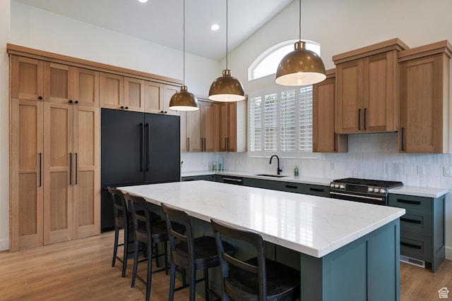1446 E Anvil Dr, Draper, UT 84020 - kitchen featuring black fridge, stainless steel gas stove, backsplash, a sink, and a kitchen island