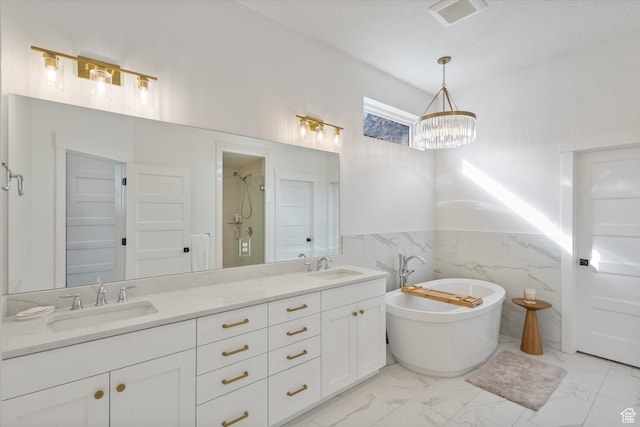 4307 N La Ringhiera Dr, Lehi, UT 84043 - bathroom with marble finish flooring, a chandelier, double vanity, a freestanding tub, and wainscoting