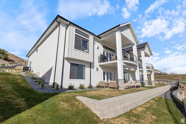 4307 N La Ringhiera Dr, Lehi, UT 84043 - rear view of house with a balcony, an outdoor living space, a lawn, and board and batten siding