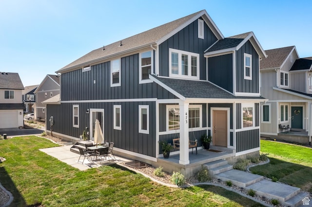 473 N Northshore Dr, Saratoga Springs, UT 84045 - back of house with a shingled roof, a yard, board and batten siding, and a patio area