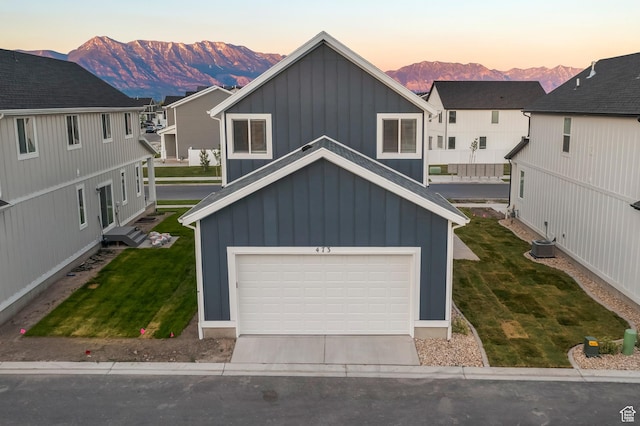 473 N Northshore Dr, Saratoga Springs, UT 84045 - view of front of house featuring board and batten siding, a mountain view, a lawn, concrete driveway, and a garage