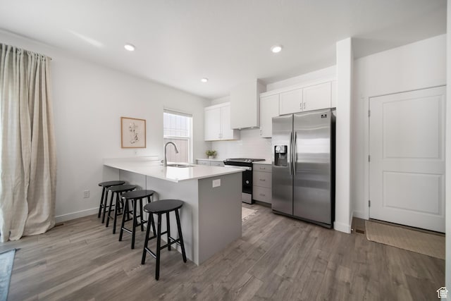 473 N Northshore Dr, Saratoga Springs, UT 84045 - kitchen with appliances with stainless steel finishes, a kitchen bar, a sink, a peninsula, and wood finished floors