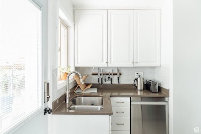 1584 E 3045 S, Salt Lake City, UT 84106 - kitchen featuring stainless steel dishwasher, tasteful backsplash, a sink, and white cabinetry