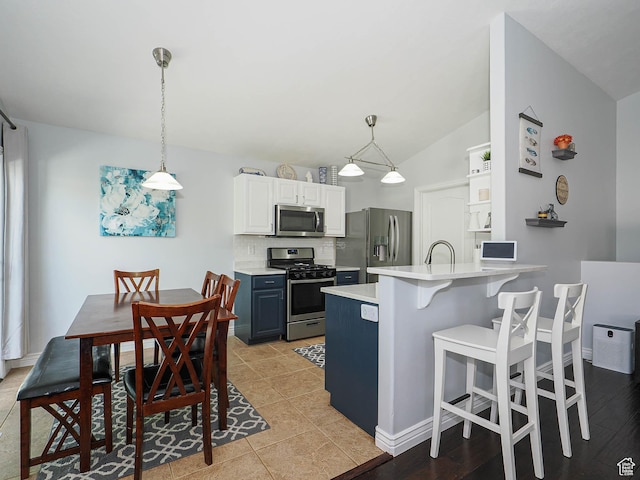 67 N Archmore St, Saratoga Springs, UT 84043 - kitchen featuring stainless steel appliances, a peninsula, a breakfast bar, light countertops, and decorative backsplash