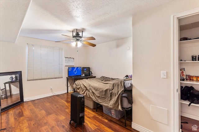 3681 W 775 N, Layton, UT 84041 - bedroom featuring dark wood finished floors, a textured ceiling, radiator heating unit, a ceiling fan, and baseboards