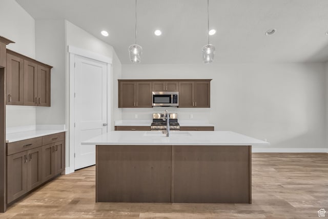 2711 S Allison Way Unit 101, Syracuse, UT 84075 - kitchen featuring stainless steel microwave, a sink, light wood-style floors, light countertops, and baseboards