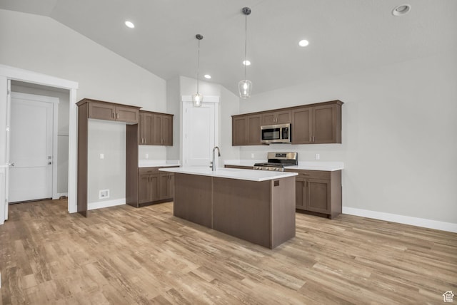 2711 S Allison Way Unit 101, Syracuse, UT 84075 - kitchen featuring appliances with stainless steel finishes, lofted ceiling, light countertops, baseboards, and light wood-style flooring