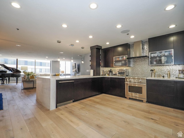 48 W 300 S Unit 2502-N, Salt Lake City, UT 84101 - kitchen with wall chimney exhaust hood, stainless steel stove, modern cabinets, light countertops, and decorative backsplash