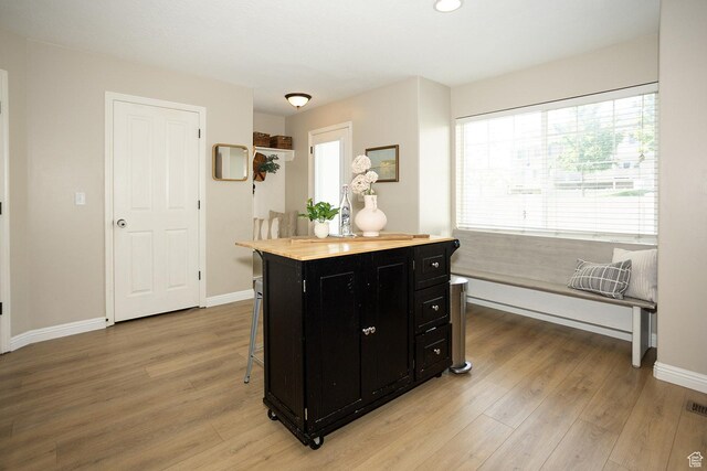 1908 W 1020 N, Provo, UT 84604 - kitchen featuring dark cabinetry, light wood-style floors, baseboards, a kitchen bar, and recessed lighting