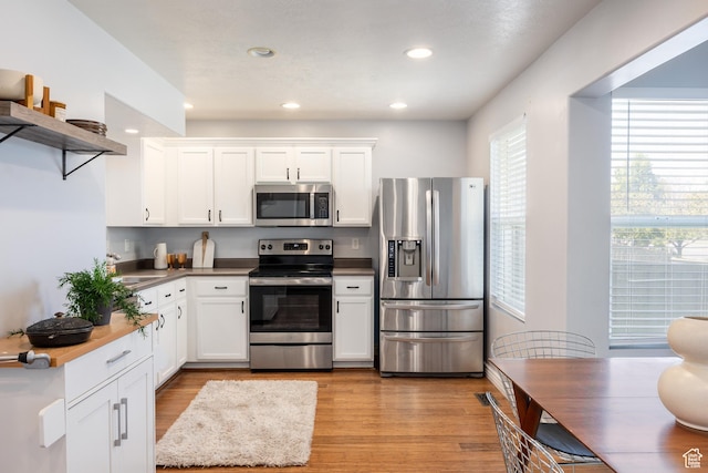 3421 E Dundee Dr, Eagle Mountain, UT 84005 - kitchen featuring appliances with stainless steel finishes, open shelves, light wood finished floors, a sink, and white cabinetry