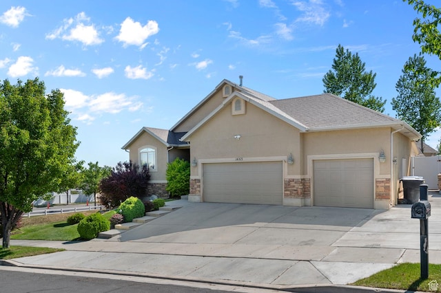 14163 S Friendship Dr W, Herriman, UT 84065 - view of front of home featuring stucco siding, a garage, concrete driveway, and stone siding